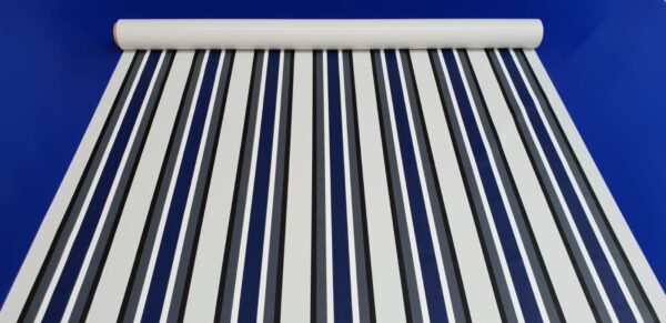Eine Stoffrolle mit vertikalen Streifen in Marineblau und Weiß ist vor einem einfarbig blauen Hintergrund ausgebreitet.
